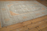 Corner detail of distressed Oushak rug, low pile, muted ivory field, pale tangerine turtle border.