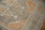 Close-up of distressed Oushak rug pile, featuring faded ivory, silver, and pale tangerine hues.