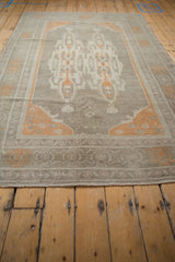 Distressed vintage Oushak rug's low pile edge with muted tangerine border.