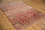 Close-up of a Farahan Sarouk rug's intricate floral palmettes and abrashes in fuchsia and pale bronze.