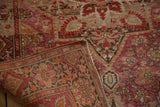 Corner of vintage Farahan Sarouk rug reveals fuchsia florals, abrashes, and woven back.