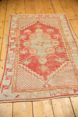 Distressed texture and bright red stylized border pattern on a vintage Oushak rug.