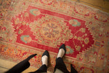 Distressed Oushak rug showing faded raspberry, tangerine, and aqua geometric lotus motifs.