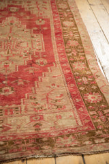 Distressed low pile, faded raspberry red and pale bronze geometric field and border.