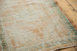 Textured pile of vintage distressed Oushak rug, even wear reveals apricot, ivory, turquoise.