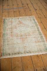 Reverse of a distressed Oushak rug, revealing foundation weave, exposed knot heads, and turquoise edge.