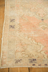 Vintage distressed Oushak rug detail, showing worn pile texture and blush-ivory palette.