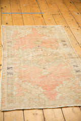 Distressed Oushak rug corner with secured side, blush, beige tones, and knot head wear.