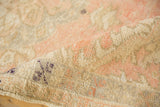 Distressed Oushak rug texture with soft blush, beige, and visible foundation.