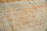 Distressed vintage Oushak rug showing even wear to foundation, faded apricot and navy patterns.