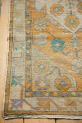 Distressed Oushak runner pile, revealing foundation, pale yellow and turquoise floral motifs.