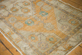 Distressed saffron yellow and ivory floral pattern on a vintage Oushak rug runner edge.