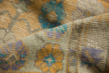 Textured distressed Oushak rug pile with worn knot heads, showing saffron, aqua, and mauve.