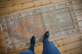 Distressed Oushak rug texture with faded orange and silver tones, exposed foundation.