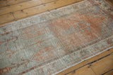 Distressed vintage Oushak runner, highlighting faded orange, soft green tones, and pile wear.