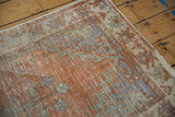 Faded orange distressed Oushak rug pile with visible foundation and gray geometric border.