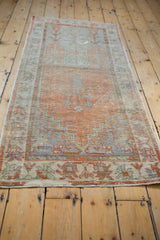 Distressed fringe and geometric border of a vintage Oushak runner in muted orange and silver.