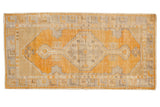 Distressed Oushak runner with gold orange diamond medallion and antique ivory patterns.