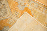 Hand-knotted ivory foundation and worn gold orange pile texture of a vintage Oushak rug.