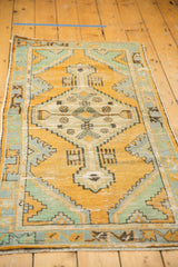 Distressed Oushak runner's diamond medallion, elongated finials, gold orange, and mint green.