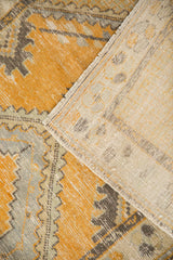 Distressed tangerine orange and grey Oushak rug pile with foundation showing, revealing woven reverse.
