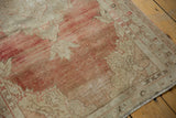 Detail of the vintage Oushak rug's low pile, showing the heavily abrashed texture and faded red hues.