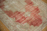 Detailed view of the vintage Oushak rug's faded red striated shading and worn knot heads.