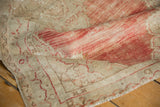 A detailed view of the distressed, low-pile weave and soft, faded cherry red shades.