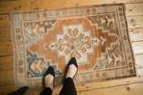Distressed Oushak rug corner detail, with worn pile and bronze starburst floral border.