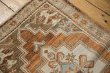 Distressed Oushak rug's stepped zig-zag pattern with bronze, copper, and sky blue tones.