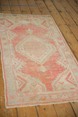 Distressed blush pink pile and geometric border of a vintage Oushak rug.
