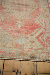Distressed Oushak rug showing worn pile, blush and beige tones, exposed foundation, and secured edge.