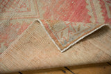 Distressed blush pink and beige pile revealing the hand-knotted reverse of the Oushak runner.