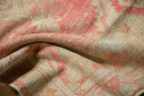 Distressed vintage Oushak rug, showing textural detail with softened blush pink and sand tones.