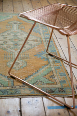 Visible wear and texture of the distressed mid-century Oushak runner's pale gold and mint pattern.