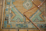 Hand-knotted Turkish Oushak runner's distressed vine and palmette border.