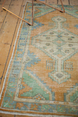 Distressed vintage Oushak runner edge, faded orange, pale gold, mint, and sky blue patterns.
