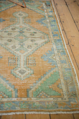 Distressed pile texture of vintage Oushak runner, pale gold, mint, and sky blue patterns.
