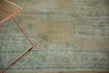 Distressed vintage Oushak carpet pile showing mostly even wear in sand and pale blue.