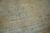 Distressed vintage Oushak carpet pile with even wear, beige field, and pale blue-green tones.