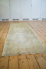 Hand knotted vintage Oushak runner, distressed with faded beige, sand, and subtle pink pattern.