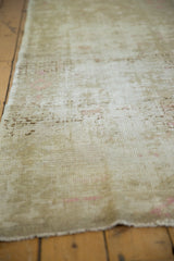 Distressed Oushak runner texture highlighting worn foundation and subtle pink tones.