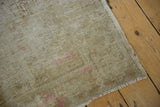 Distressed Oushak rug detail, showing exposed foundation, soft pink, and worn fringe.