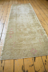 Distressed Oushak runner pile texture with soft beige and bubblegum pink.