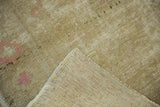 Distressed beige Oushak pile with subtle pink and visible hand-knotted reverse.
