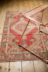Distressed vintage Oushak rug texture with pale cherry red, bronze, and ivory colors.
