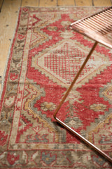 Textured distressed Oushak rug with a faded cherry red, beige, and gold pattern.