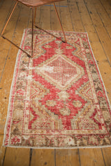Vintage distressed Oushak runner corner with fringe and textural cherry red, bronze pattern.