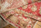 Distressed vintage Oushak rug runner with worn pile, showing pale cherry red and ivory tones.
