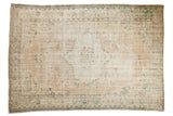 Distressed vintage Oushak rug showing even wear, ivory and green floral medallion design.